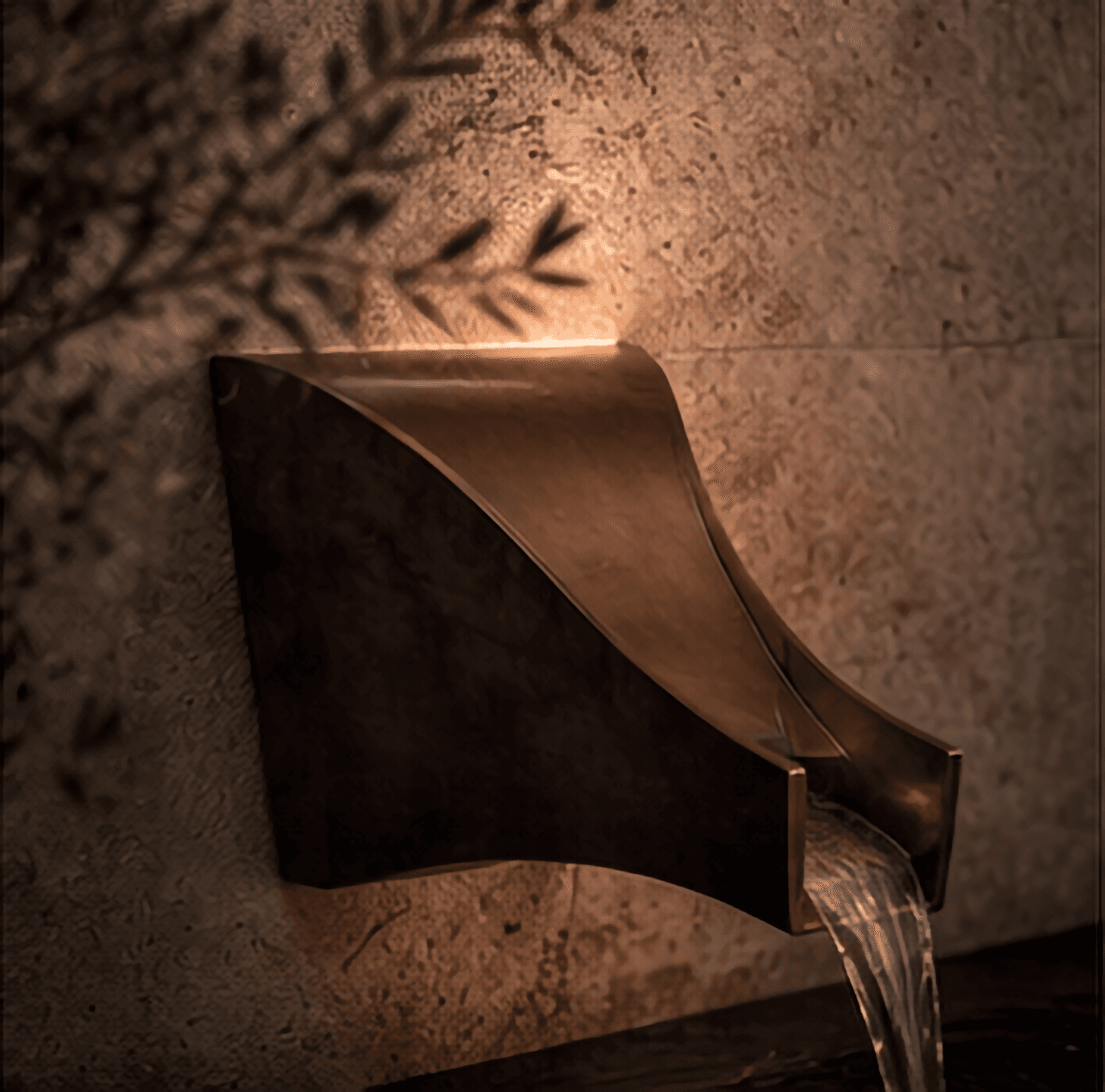 Sculpted bronze water spout against textured limestone at Sighthound Sanctuary.